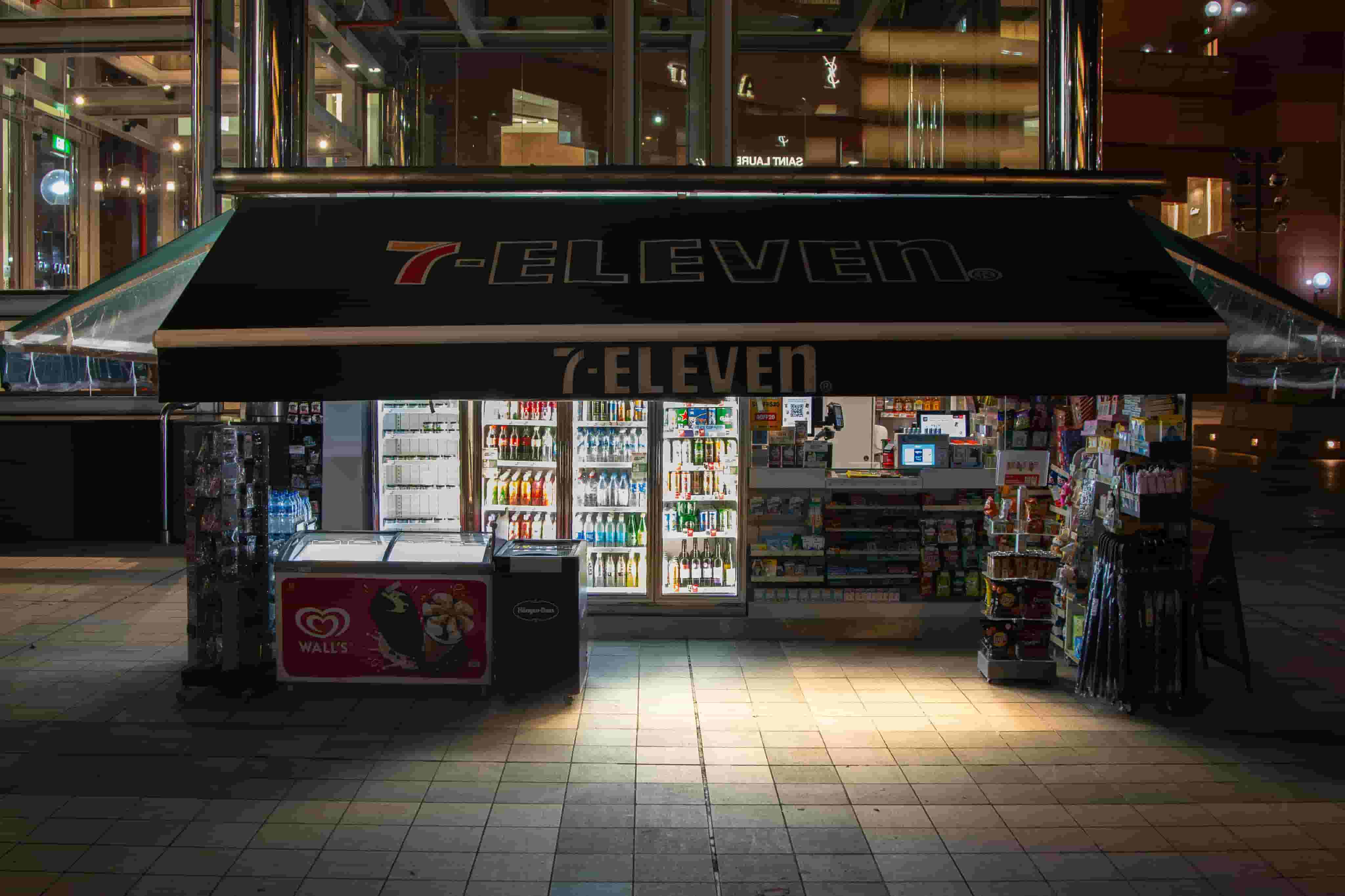 Convenience store lit up at night with drink coolers and snack displays
