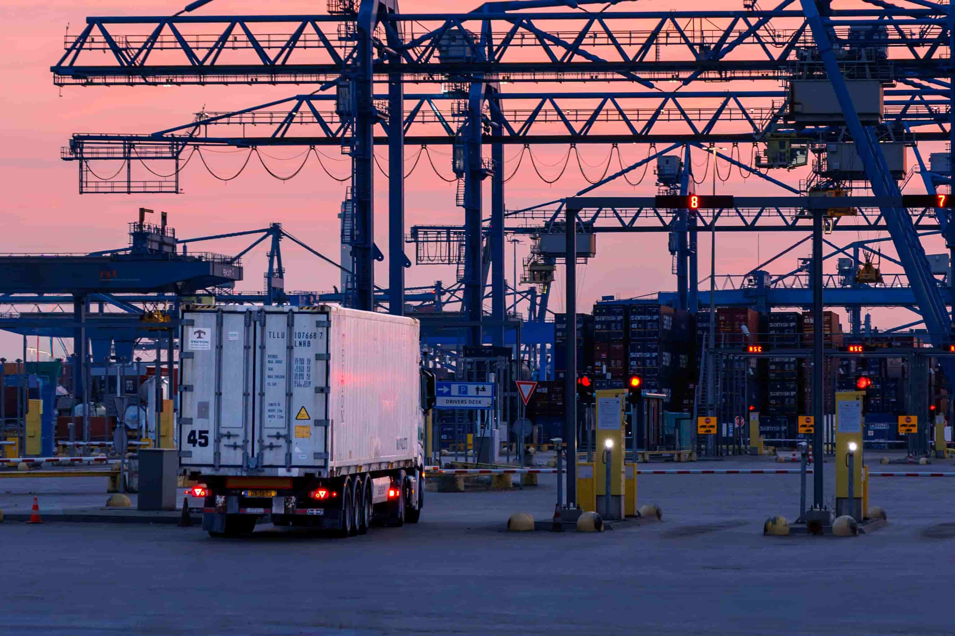 Refrigerated cargo trailer entering a container terminal gate at sunset