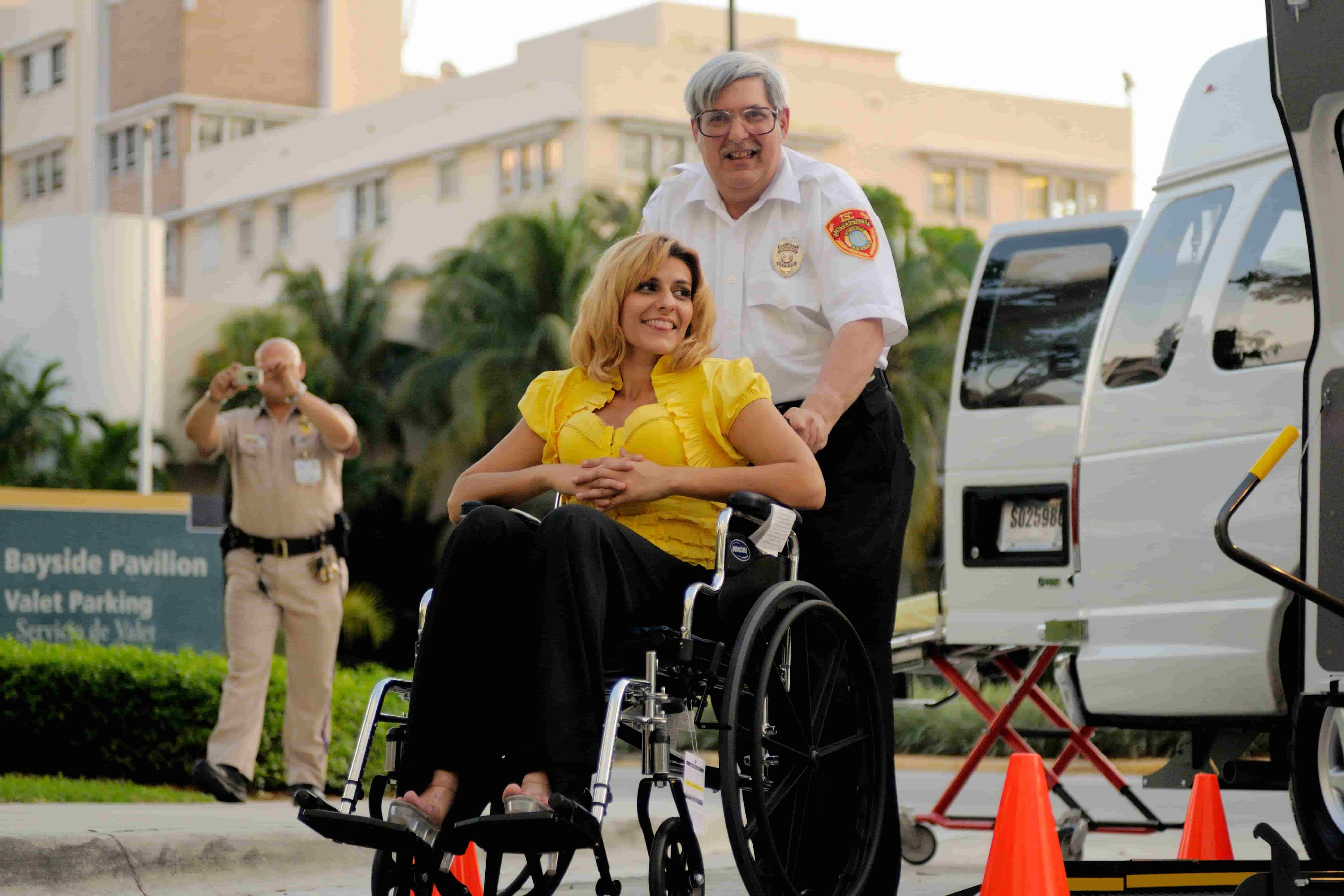 NEMT driver assisting a wheelchair passenger beside an accessible medical transport van