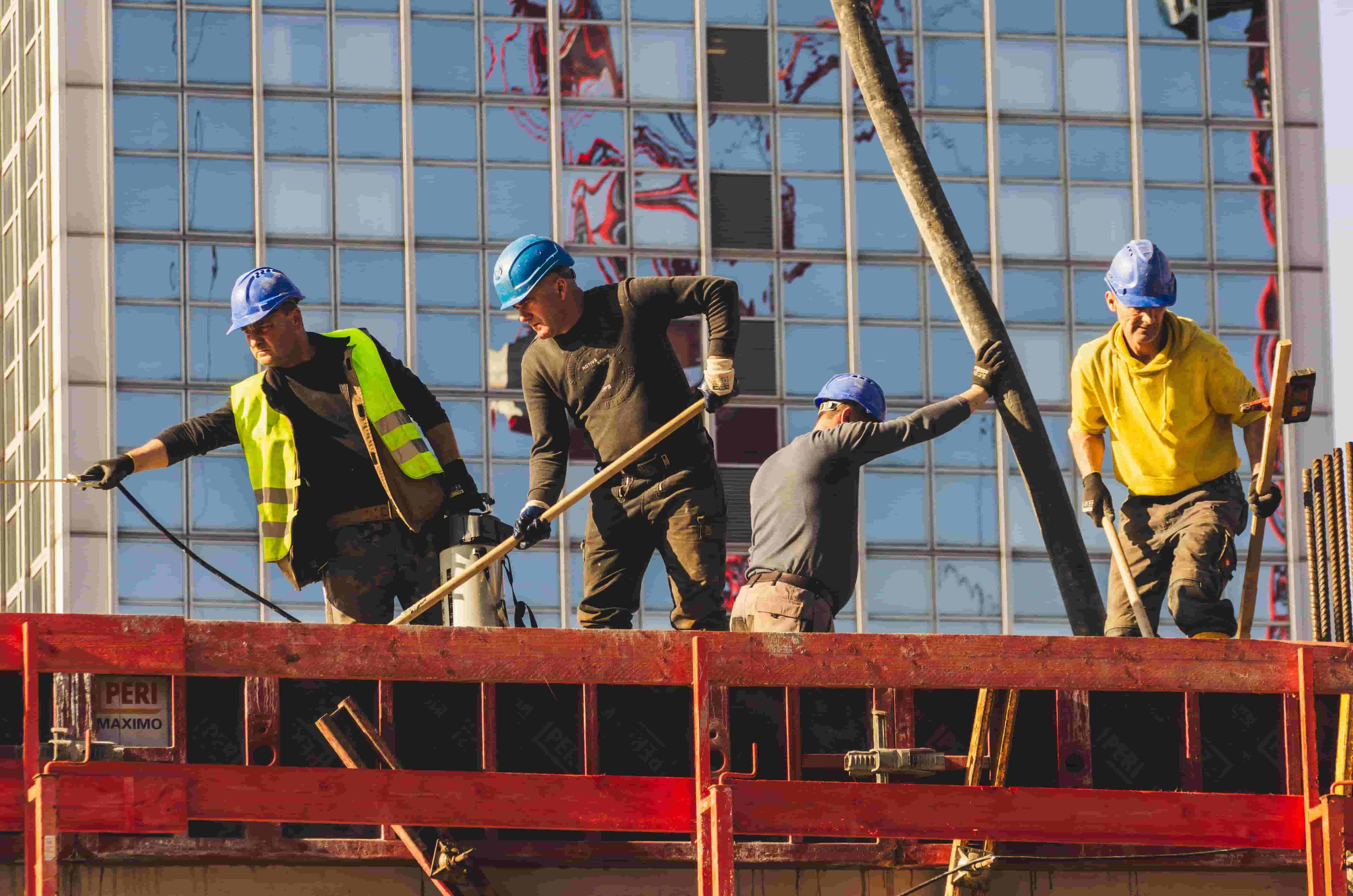 Construction crew in hard hats placing concrete on an elevated deck