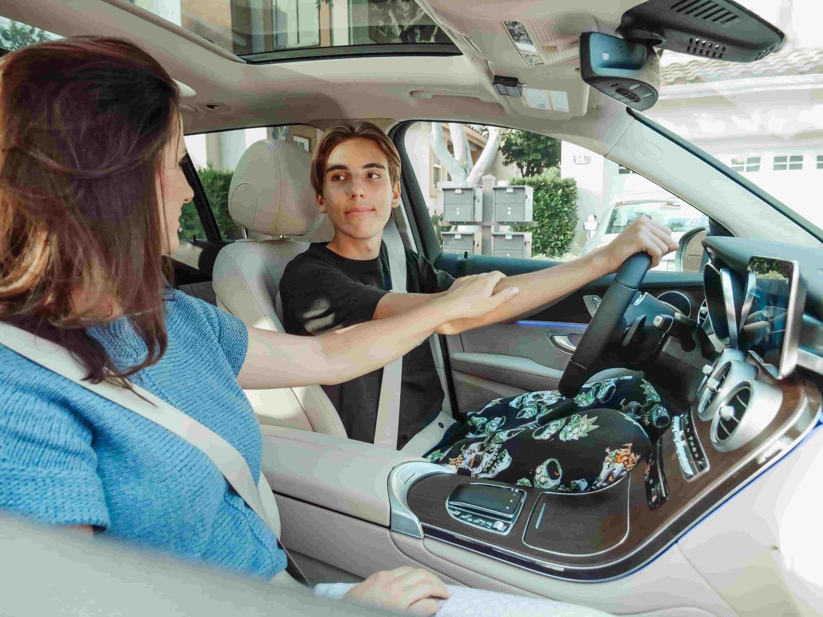 Parent handing car keys to a teenage driver during a driving lesson