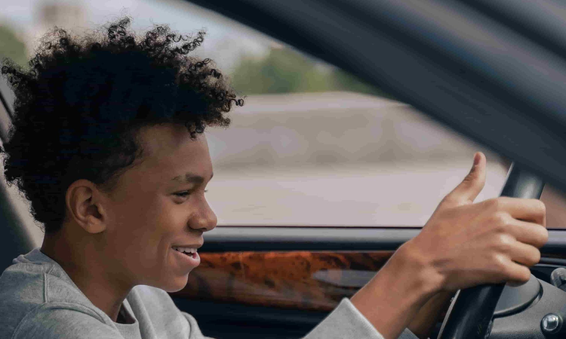 Teen driver confidently gripping the steering wheel of a car