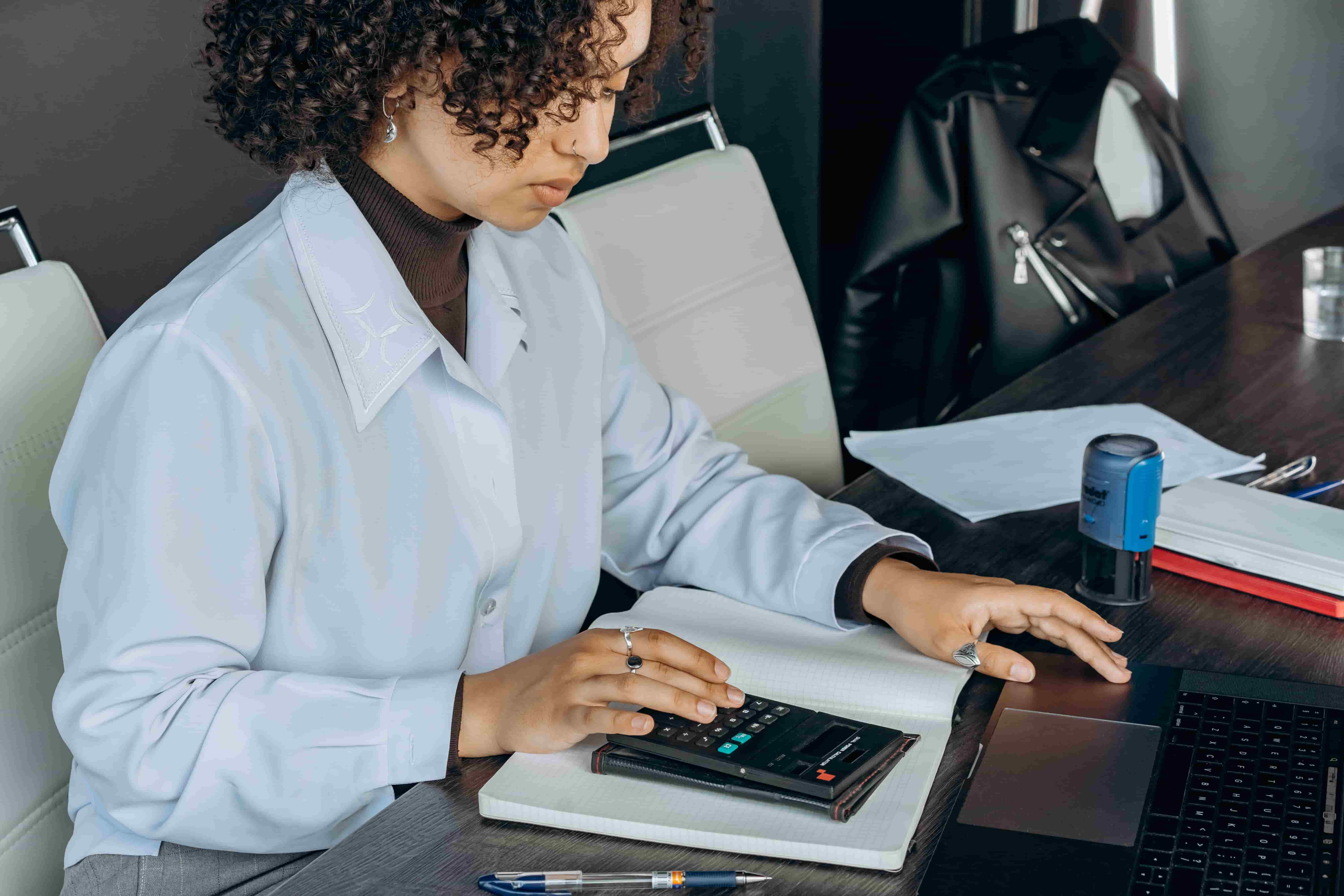 Accountant working through client figures with a calculator and notepad
