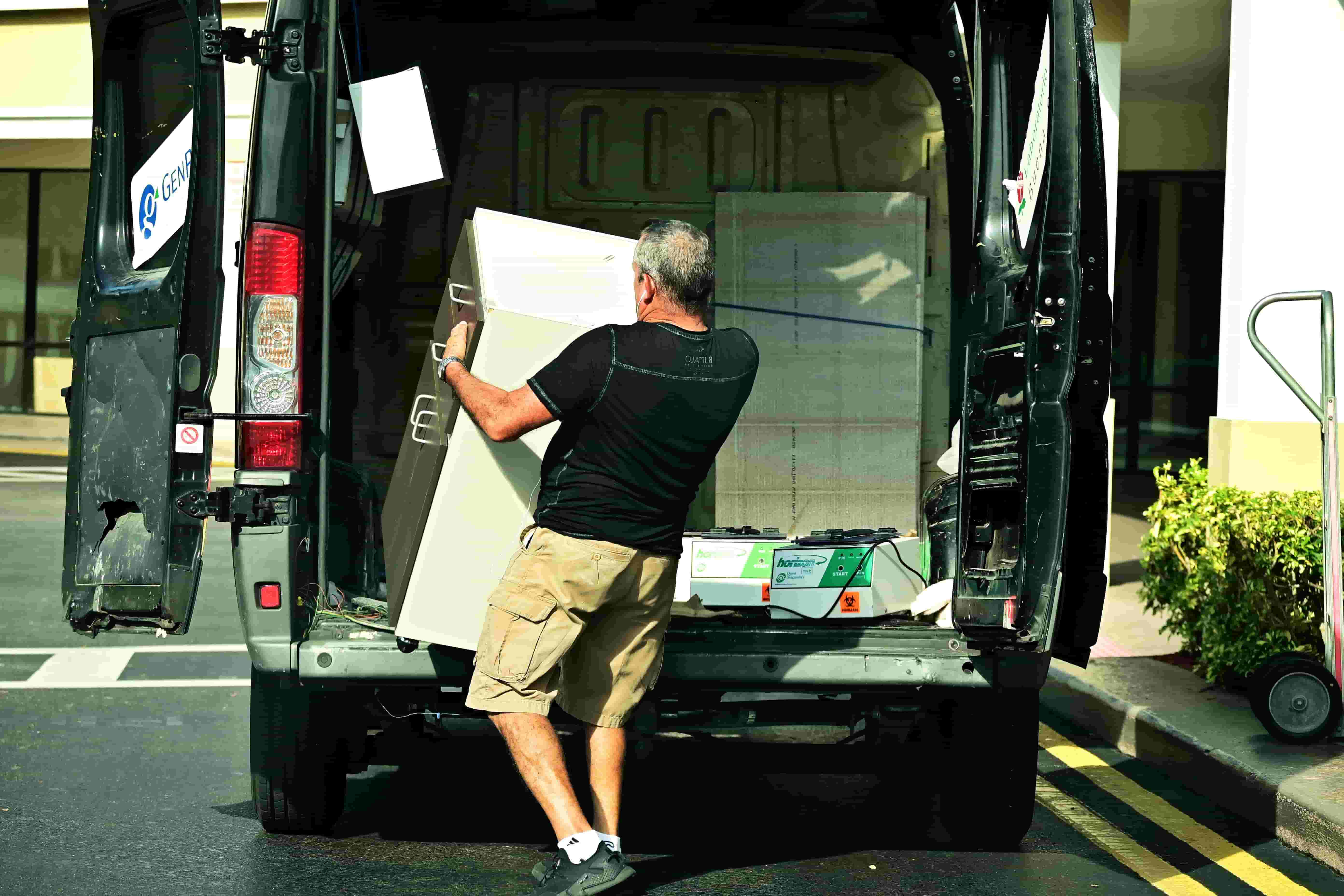 Mover carrying furniture out of the back of a moving van